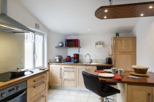 Una cocina con gabinetes de madera y una mesa de madera. en La fringante, en Pleubian