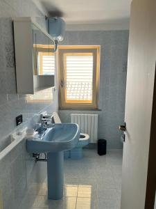 a bathroom with a blue sink and a toilet at Casa Amrita B&B in Teramo +73 photos