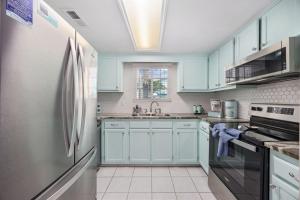 Una cocina con gabinetes azules y un refrigerador. en Pet Friendly, 3Br 2Ba Bungalow next to Beach, en Myrtle Beach