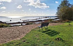 a bench sitting on the grass near the beach at 2 Bedroom Awesome Home In Abbekås in Abbekås