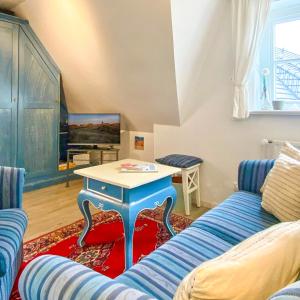 a living room with a blue couch and a table at Warfthüs, App 7 in Rantum