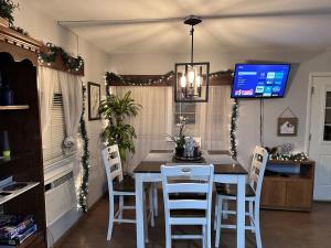Goods MillにあるThe Perch Riverfront Cabin - Starlink Wi-Fiのテーブルと白い椅子のあるダイニングルーム