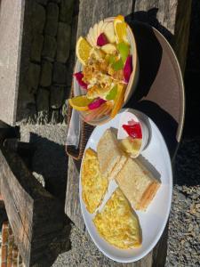 a plate of food with eggs and bread and a bowl of fruit at The hills in Pokhara