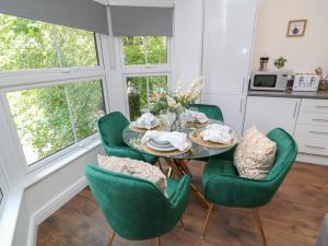 a dining room with a table and green chairs at Three in Peterborough +3 photos