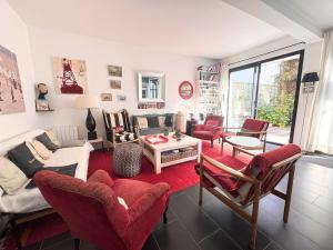 a living room with red chairs and a couch at Le Clos Maréchal in Dinard