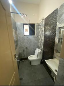 a bathroom with a toilet and a sink at Evergreen Service Apartments in Kottakkal