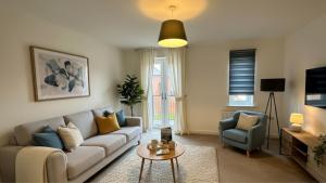 ein Wohnzimmer mit Sofa und Tisch in der Unterkunft Newcastle Great Park 4BR Home, Sleeps 8 