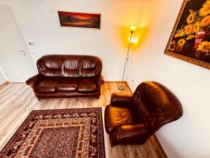 a living room with two leather chairs and a rug at Brasov 35 Classic in Braşov