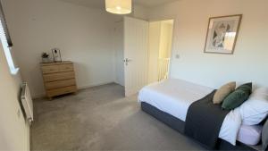 ein Schlafzimmer mit einem Bett und einer Kommode darin in der Unterkunft Newcastle Great Park 4BR Home, Sleeps 8  + 2 Fotos