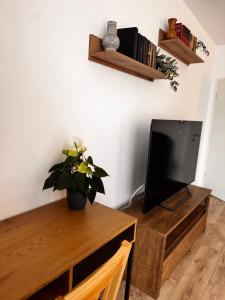 a living room with a tv and a wooden table at Brasov 35 Classic in Braşov