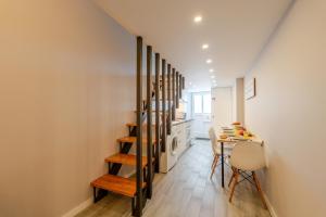a hallway with a staircase leading to a kitchen with a table at City Views Flats in Historic Porto by HostWise in Porto