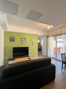 un soggiorno con divano e TV a schermo piatto di Appartements Prestiges I Draps&ménage inclus I parking privé a Saint-Lary-Soulan