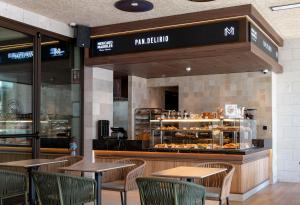 a restaurant with tables and chairs in front of a bakery at VP SOGNIO Metropolitano in Madrid