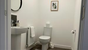 ein weißes Badezimmer mit Toilette und Waschbecken in der Unterkunft Newcastle Great Park 4BR Home, Sleeps 8 
