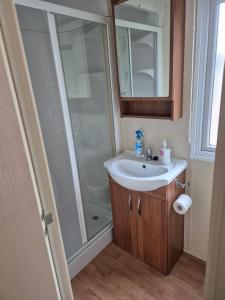 a bathroom with a sink and a shower at Caravan by the Sea 640 in Kinmel Bay