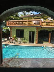 a man sitting in a chair next to a swimming pool at Hidden oasis in Mandeville