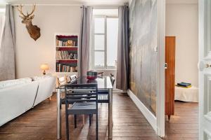 una sala da pranzo con tavolo e sedie di Magnifique appartement 90 m2 à 10 minutes de Bagnoles a La Ferté-Macé