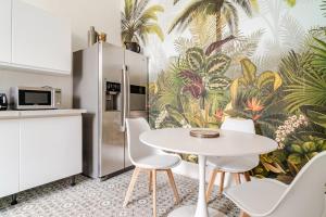 una cucina con tavolo e sedie e carta da parati tropicale di Magnifique appartement 90 m2 à 10 minutes de Bagnoles a La Ferté-Macé