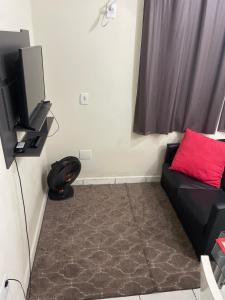 a living room with a black couch and a flat screen tv at Albuquerque nro36 casa 5 in Campinas