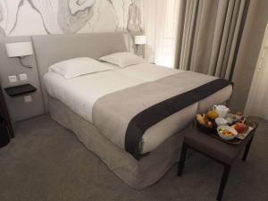 パリにあるクイーン メアリー オペラのベッドルーム1室(ベッド1台、テーブルの上にフルーツボウル付)