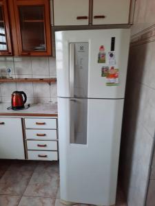 a kitchen with a white refrigerator in a kitchen at Vila Hostel Santos in Santos