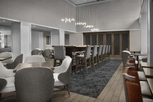 a waiting room with chairs and tables and a bar at Hampton Inn & Suites Ocean City Bayfront-Convention Center in Ocean City +37 photos
