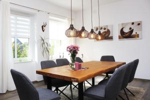 a dining room with a wooden table and chairs at Ferienwohnung Schwienaublick in Ebstorf