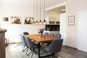 a dining room with a wooden table and chairs at Ferienwohnung Schwienaublick in Ebstorf