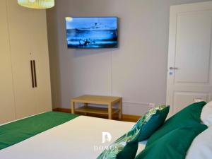 a bedroom with a bed with a tv on the wall at Domus Derthona Alloggio Ester Mietta in Tortona