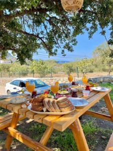a picnic table with food and glasses of orange juice at Karaincirevleri in Emecik