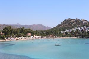 a beach with a bunch of people in the water at Karaincirevleri in Emecik +37 photos
