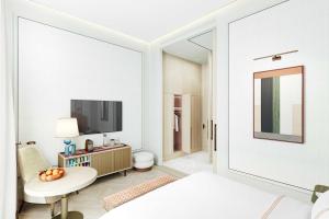 a white room with a bed and a tv at Áurea Palacio de la Tinta in Málaga