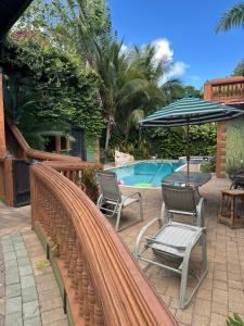 a patio with chairs and an umbrella next to a pool at Hidden oasis in Mandeville