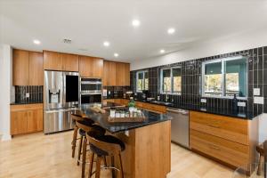 Una cocina con gabinetes de madera y una encimera negra. en Group Retreat Fairhope, en Fairhope