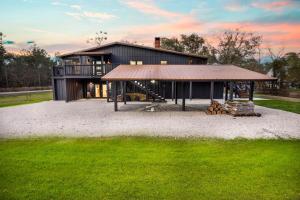 Una gran casa negra con un gran patio con césped. en Group Retreat Fairhope, en Fairhope