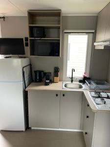 a small kitchen with a sink and a refrigerator at LetzCamp Mullerthal-Lodge 6 Pers in Beaufort +4 photos