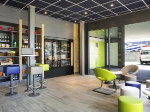 a lobby with chairs and tables in a building at ibis budget Fribourg in Fribourg