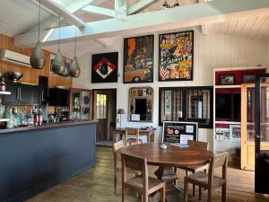 ein Esszimmer mit einem Tisch und einer Bar in der Unterkunft Chambre d'Hôtes - Village Petit Piquey in Cap-Ferret