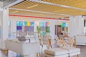 a living room with white furniture and colorful ceilings at Experience The Groovy Harbour House Lifestyle in Oranjestad
