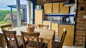 Boerenslag 44 في سينت مارتنسي: مطبخ وغرفة طعام مع طاولة وكراسي خشبية