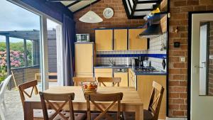 Boerenslag 44 في سينت مارتنسي: مطبخ وغرفة طعام مع طاولة وكراسي