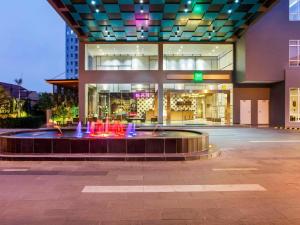 a building with a fountain in front of a building at ibis Styles Bekasi Jatibening in Bekasi