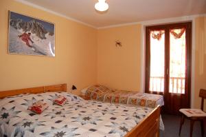 a bedroom with two beds and a window at Case Gran Paradiso Rhemes Notre Dame Piazza in Rhêmes-Notre-Dame