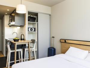 Habitación de hotel con cama y mesa pequeña en Aparthotel Adagio access Palaiseau Saclay, en Palaiseau 59 fotos más