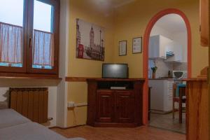 a living room with a tv and an arched doorway at Case Gran Paradiso Rhemes Notre Dame Piazza in Rhêmes-Notre-Dame