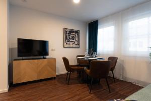 uma sala de jantar com uma mesa e uma televisão de ecrã plano em Loft Apartments - nähe Hautbahnhof - urbane Umgebung - Küche em Nuremberga