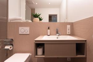 um banheiro com uma pia, um vaso sanitário e um espelho em Loft Apartments - nähe Hautbahnhof - urbane Umgebung - Küche em Nuremberga mais 40 fotografias