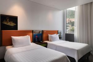 two beds in a hotel room with a window at Hampton by Hilton Bogota Usaquen in Bogotá