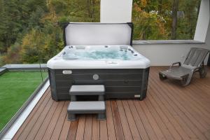 a hot tub on a deck with a chair at Quantara Resort Domaša in Holčíkovce