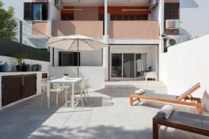 a patio with an umbrella and a table and chairs at NUZZA - Vilamoura Marina with BBQ in Vilamoura